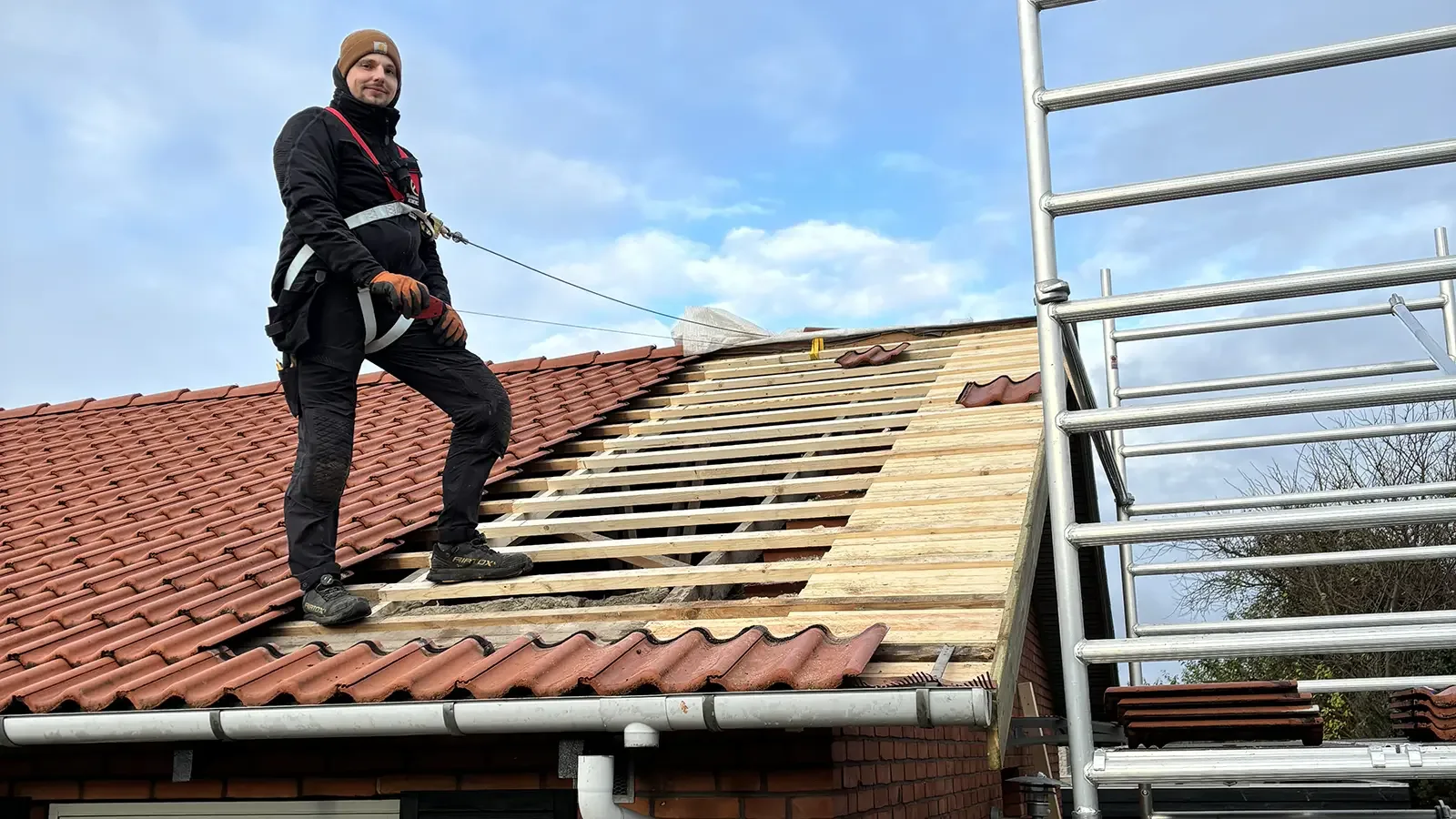 Tømrer sikret med sele under renovering af tegltag